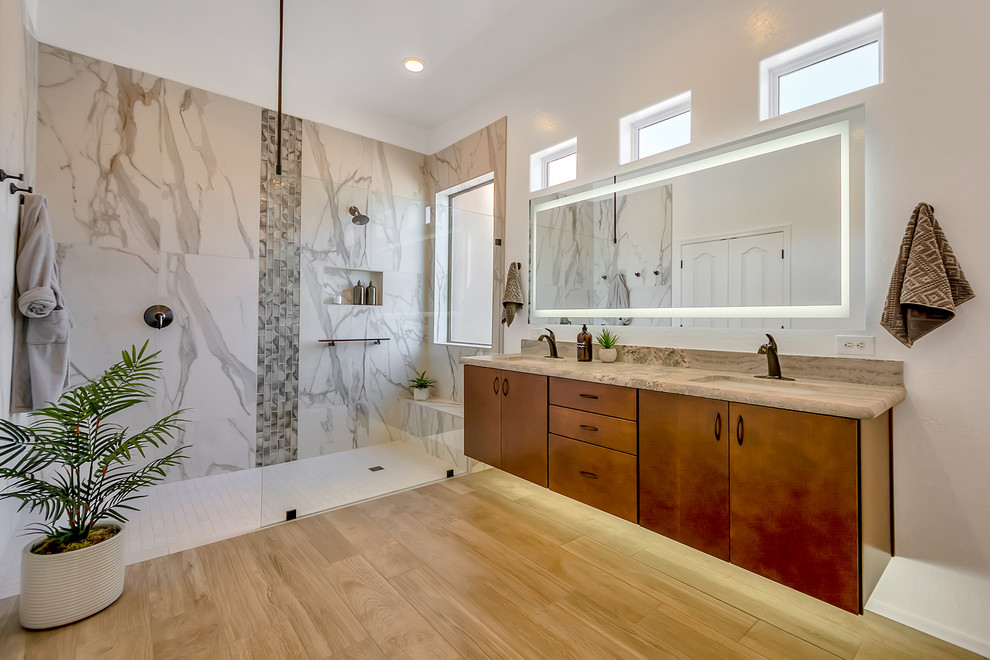 Mid-sized contemporary master bathroom in Phoenix with flat-panel cabinets, medium wood cabinets, a curbless shower, a two-piece toilet, white tile, porcelain tile, white walls, porcelain floors, an undermount sink, granite benchtops, brown floor, an open shower and grey benchtops.