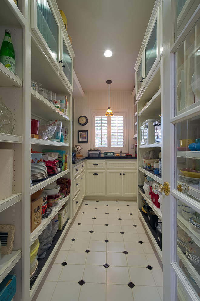 Photo of a mid-sized arts and crafts galley kitchen pantry in Los Angeles with shaker cabinets, white cabinets, granite benchtops, ceramic floors, an undermount sink, black splashback, stone slab splashback, white appliances and no island.