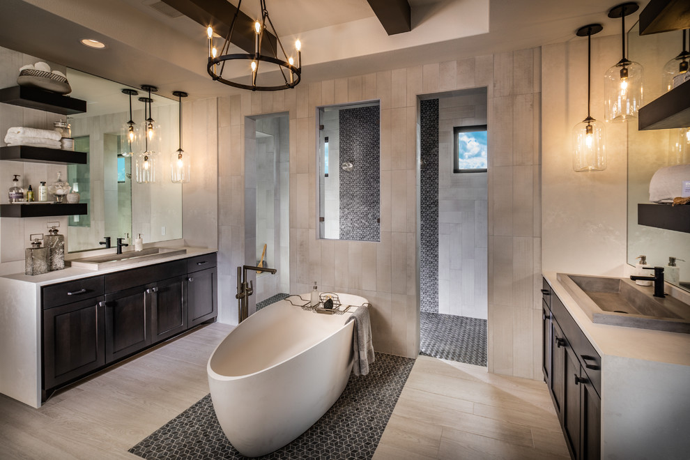 Photo of an expansive contemporary master bathroom in Austin with dark wood cabinets, a freestanding tub, a double shower, porcelain floors, a drop-in sink, shaker cabinets, beige tile, beige walls, beige floor and beige benchtops.