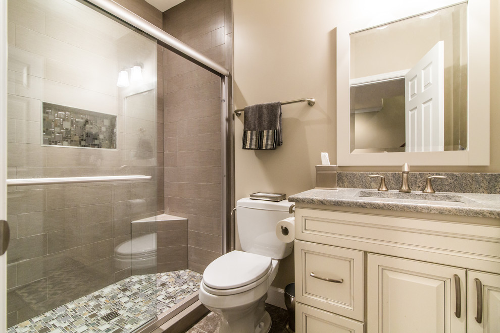 Design ideas for a mid-sized transitional 3/4 bathroom in DC Metro with raised-panel cabinets, white cabinets, an alcove shower, a two-piece toilet, gray tile, porcelain tile, beige walls, porcelain floors, an undermount sink, granite benchtops, grey floor and a sliding shower screen.