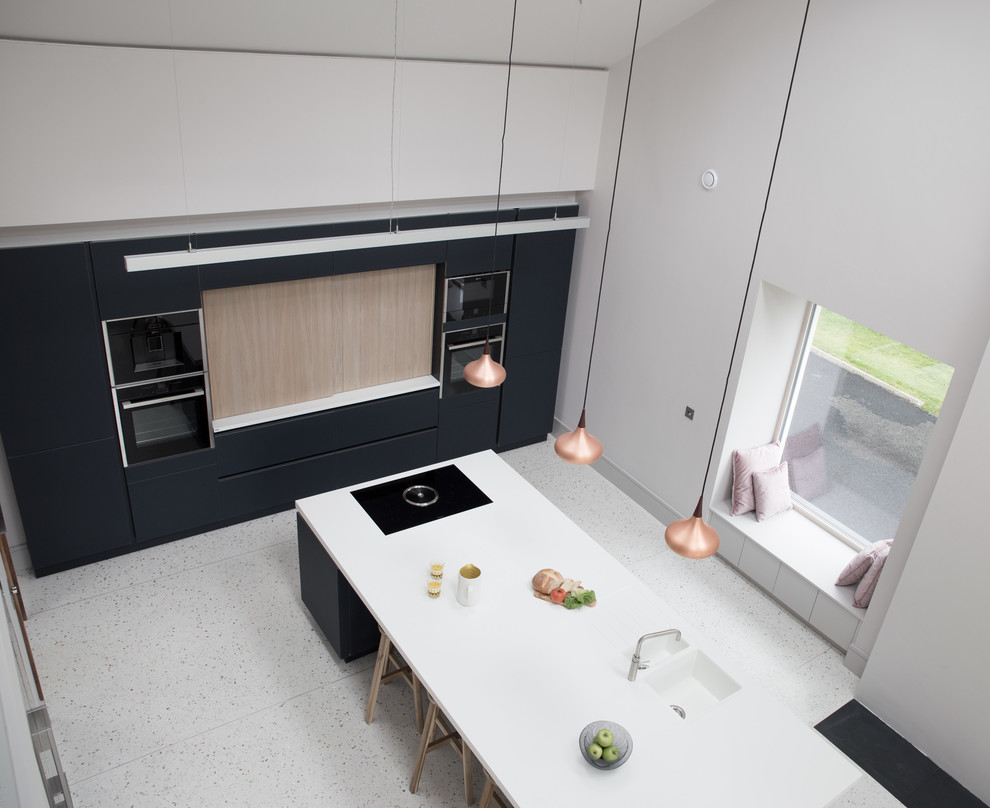 Inspiration for a large modern single-wall kitchen in Other with an integrated sink, glass-front cabinets, blue cabinets, solid surface benchtops, black appliances, concrete floors, with island and grey floor.