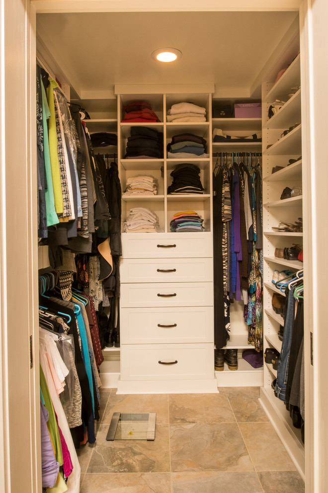 Photo of a mid-sized transitional women's walk-in wardrobe in Raleigh with white cabinets, shaker cabinets, porcelain floors and beige floor.
