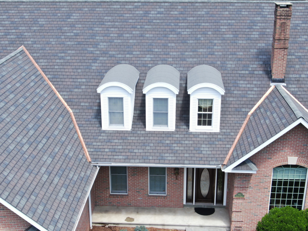 Immagine della villa grande marrone contemporanea a due piani con rivestimento in mattoni, tetto a capanna, copertura a scandole e tetto nero