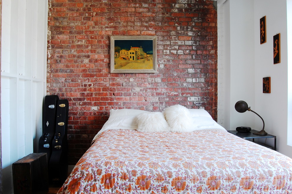 Industrial bedroom in New York with white walls.