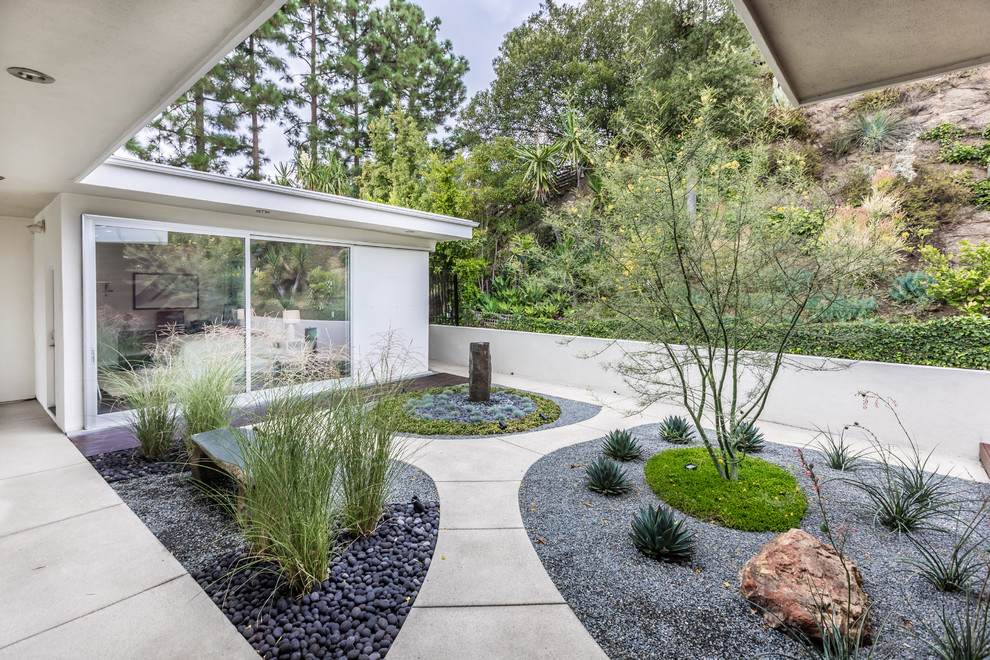 This is an example of a mid-sized contemporary full sun xeriscape in Los Angeles with concrete pavers.