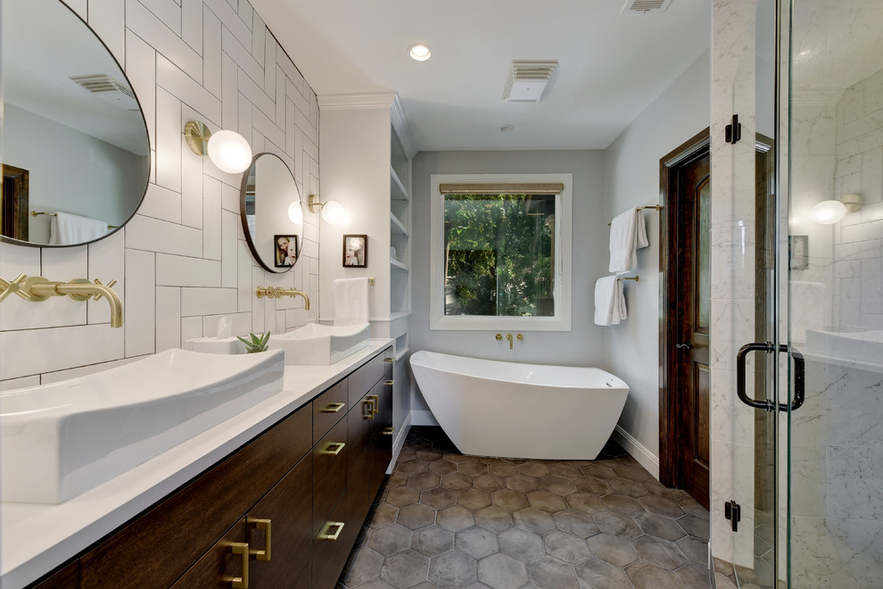 Country master bathroom in Austin with flat-panel cabinets, dark wood cabinets, a freestanding tub, an alcove shower, white tile, grey walls, cement tiles, a drop-in sink, grey floor, a hinged shower door and white benchtops.