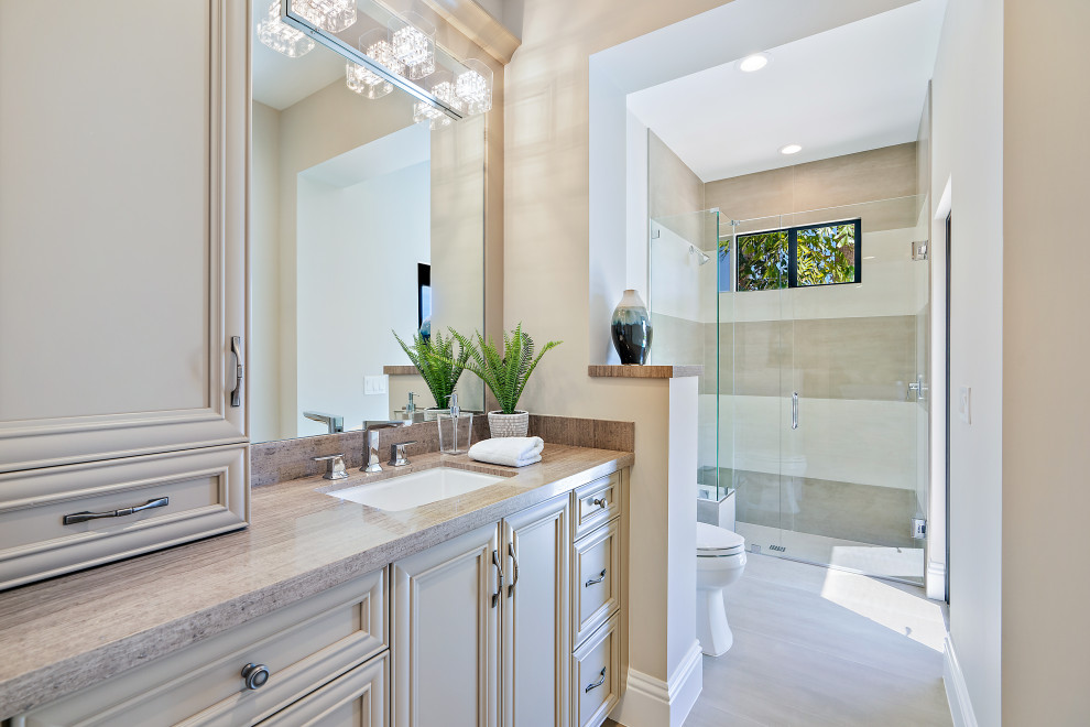 Transitional master bathroom in Miami with recessed-panel cabinets, beige cabinets, a curbless shower, beige tile, white tile, an undermount sink, beige floor, a hinged shower door and beige benchtops.
