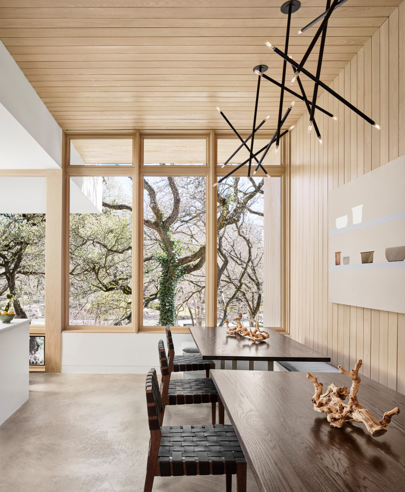 Retro Esszimmer mit Betonboden, grauem Boden, Holzdecke und Holzwänden in Austin