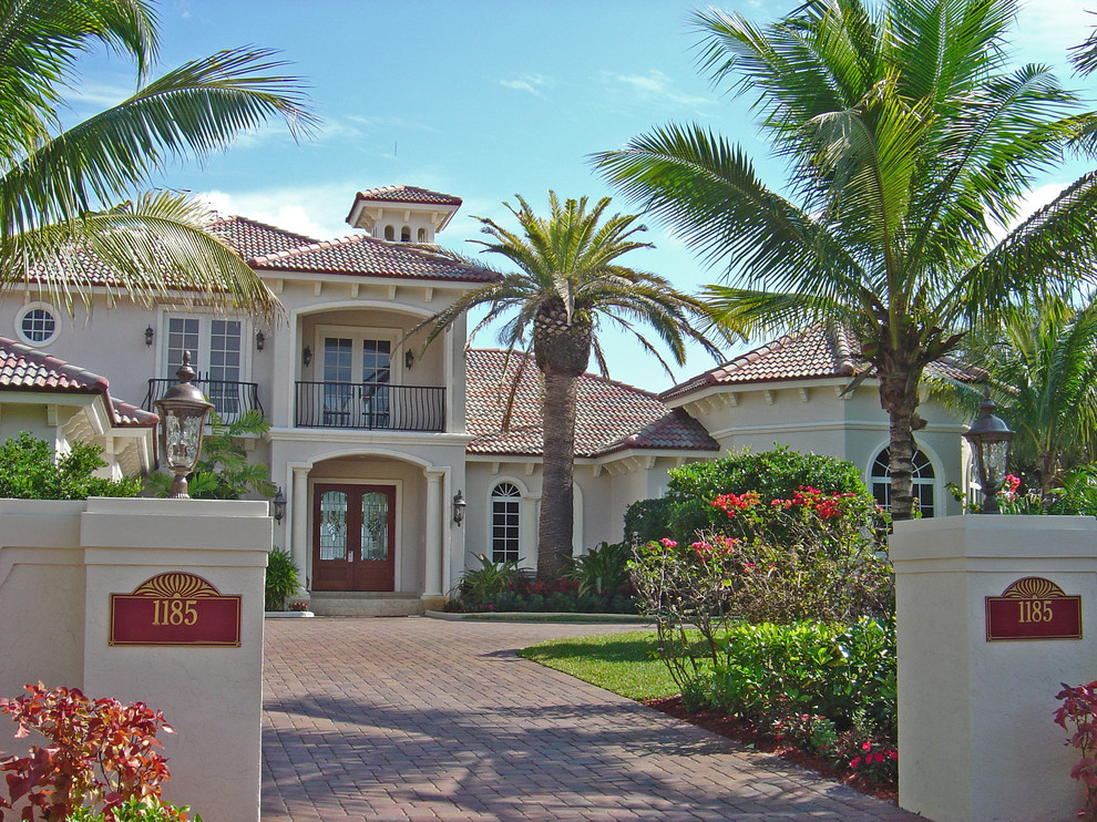 Large mediterranean two-storey stucco beige exterior in Miami with a hip roof.