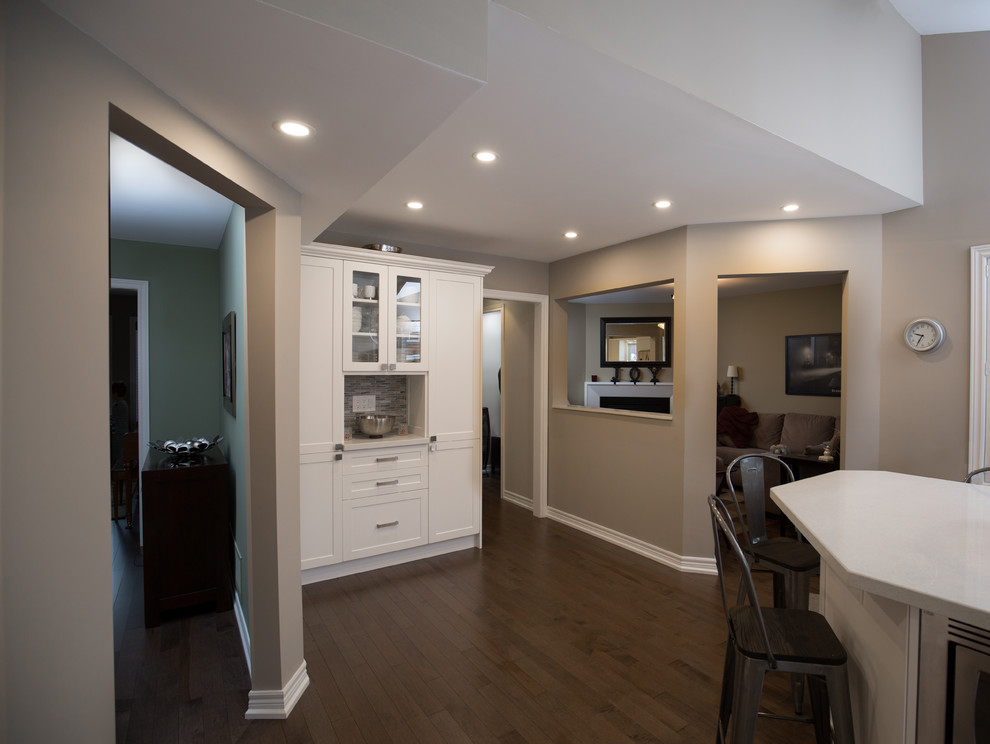 Inspiration for a mid-sized transitional u-shaped medium tone wood floor and brown floor open concept kitchen remodel in Toronto with a double-bowl sink, recessed-panel cabinets, white cabinets, quartz countertops, gray backsplash, marble backsplash, stainless steel appliances, no island and white countertops