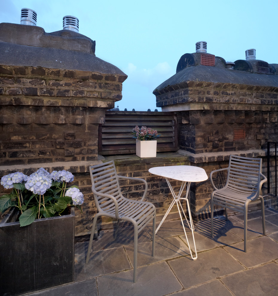 Photo of a traditional rooftop and rooftop deck in London with no cover.