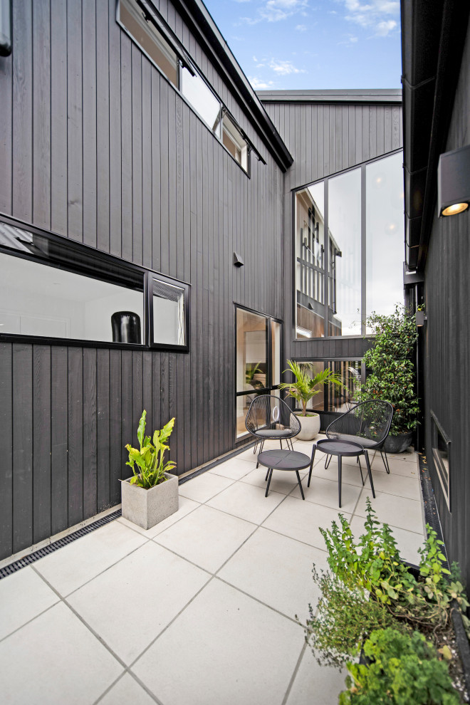 Imagen de patio industrial de tamaño medio en patio y anexo de casas con entablado