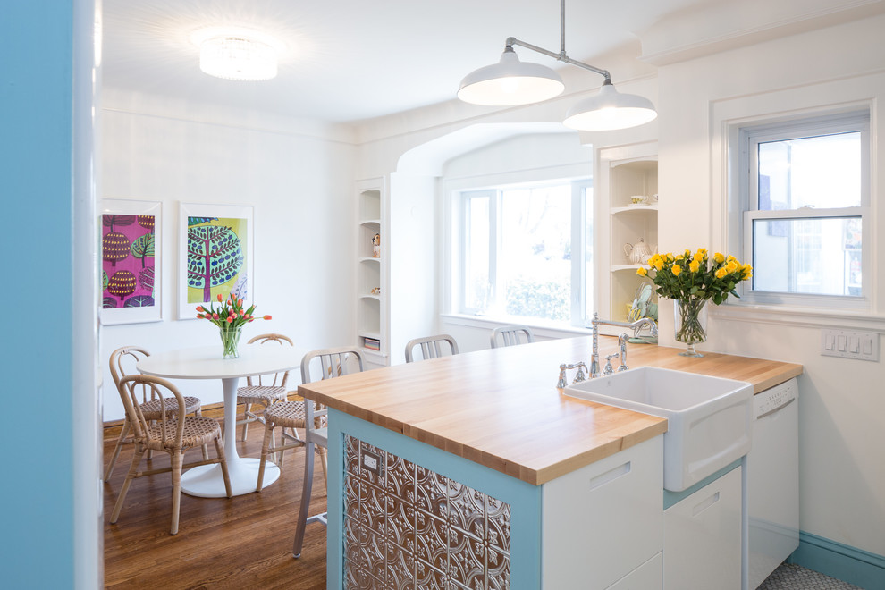 Inspiration for a small transitional l-shaped marble floor eat-in kitchen remodel in Toronto with a farmhouse sink, flat-panel cabinets, white cabinets, wood countertops, white backsplash, subway tile backsplash, colored appliances and a peninsula