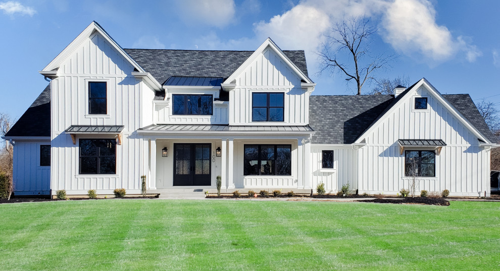 Exemple d'une grande façade de maison blanche nature en panneau de béton fibré et planches et couvre-joints de plain-pied avec un toit à deux pans, un toit mixte et un toit noir.