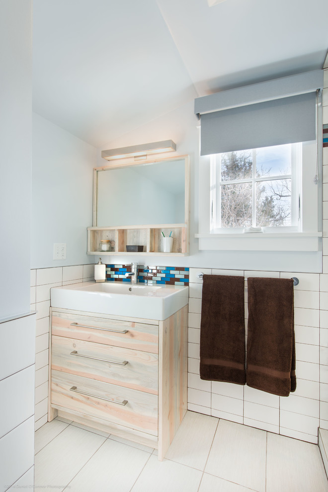 Example of a transitional white tile bathroom design in Denver with flat-panel cabinets, light wood cabinets and an integrated sink