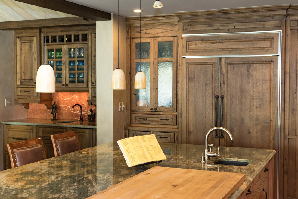 Inspiration for a large rustic u-shaped eat-in kitchen remodel with distressed cabinets, granite countertops, stone slab backsplash, stainless steel appliances and an island