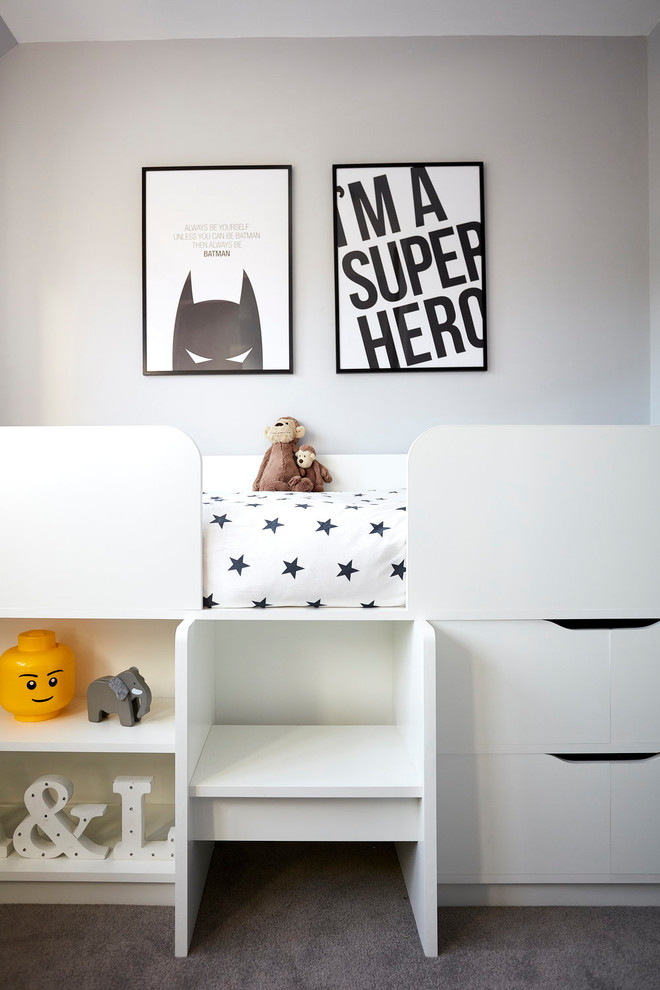 Photo of a mid-sized contemporary gender-neutral kids' bedroom for kids 4-10 years old in London with grey walls, carpet and grey floor.