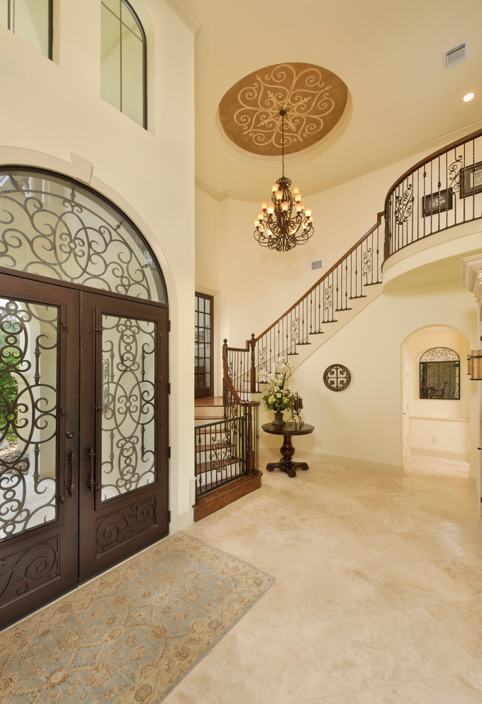 Traditional entryway in Houston with a glass front door, a double front door and beige floor.