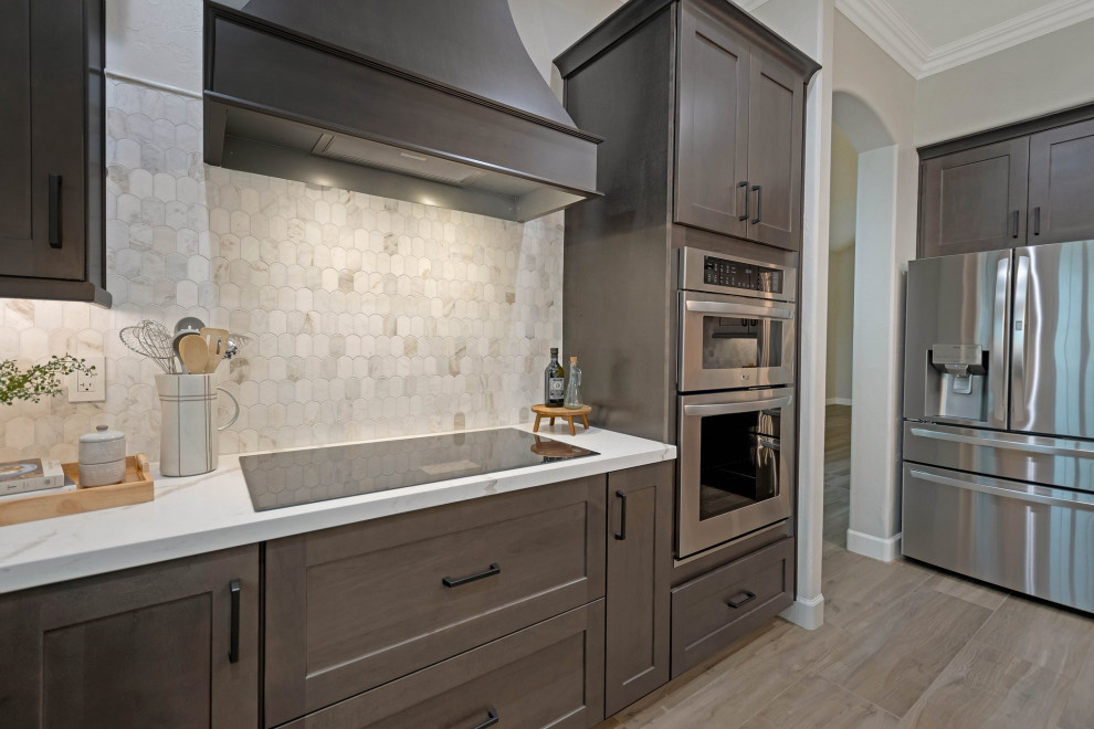 Large porcelain tile and brown floor eat-in kitchen photo in Phoenix with an undermount sink, shaker cabinets, quartz countertops, multicolored backsplash, marble backsplash, stainless steel appliances, an island and white countertops