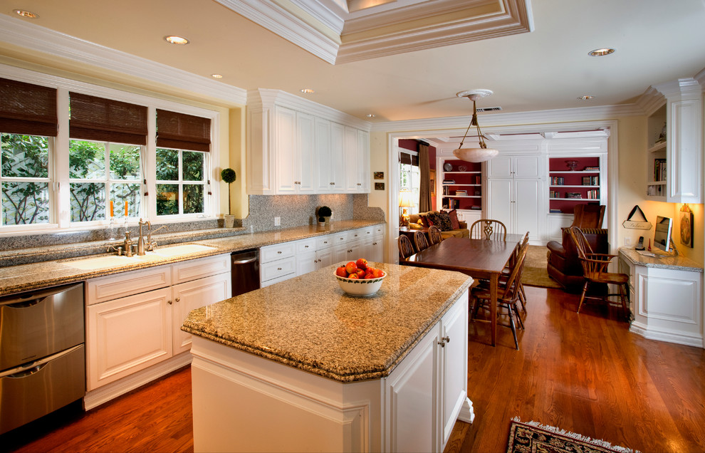 Photo of a traditional eat-in kitchen in Orange County with raised-panel cabinets, white cabinets and stainless steel appliances.