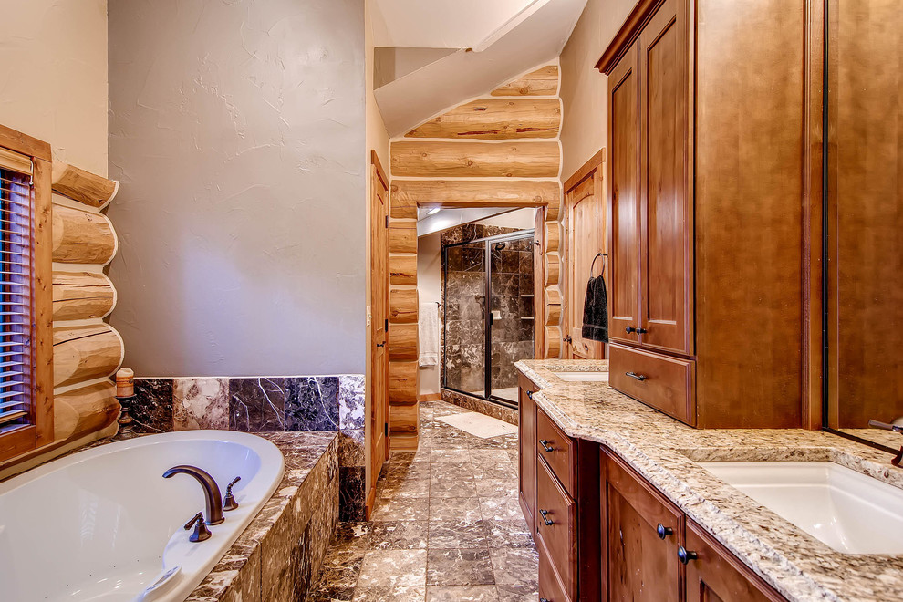 This is an example of a large master bathroom in Denver with a drop-in sink, recessed-panel cabinets, medium wood cabinets, a drop-in tub, an alcove shower, brown tile, grey walls and ceramic floors.