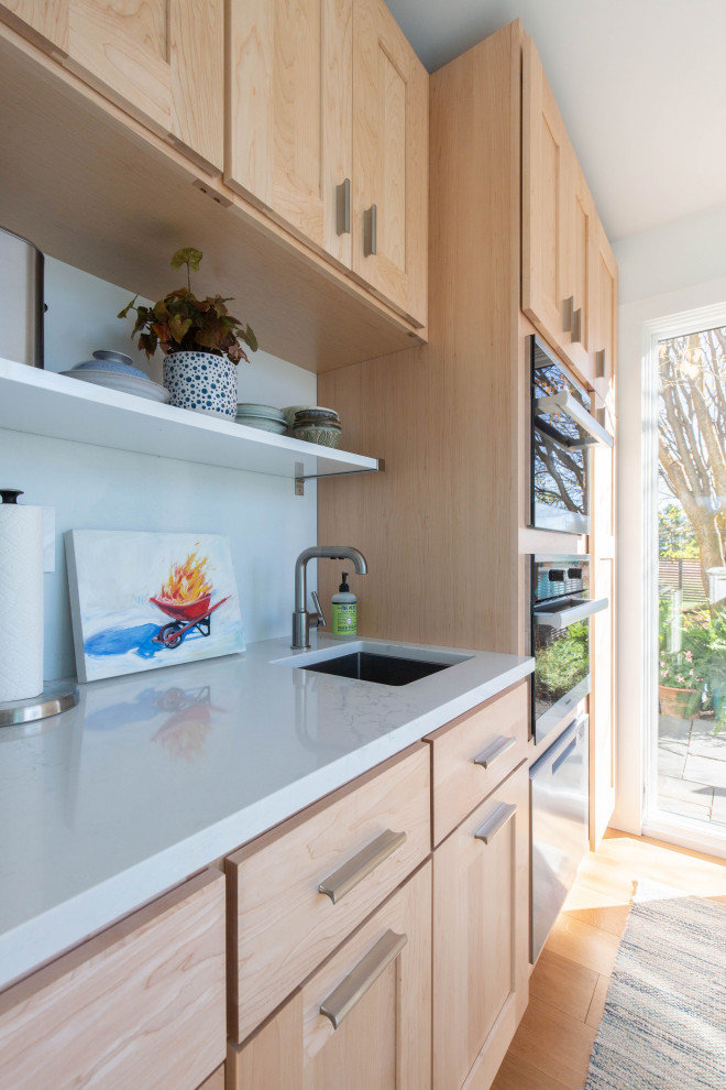 Idee per una cucina scandinava di medie dimensioni con ante in stile shaker, ante blu, top in quarzo composito, paraspruzzi bianco, pavimento in legno massello medio, pavimento marrone e top bianco