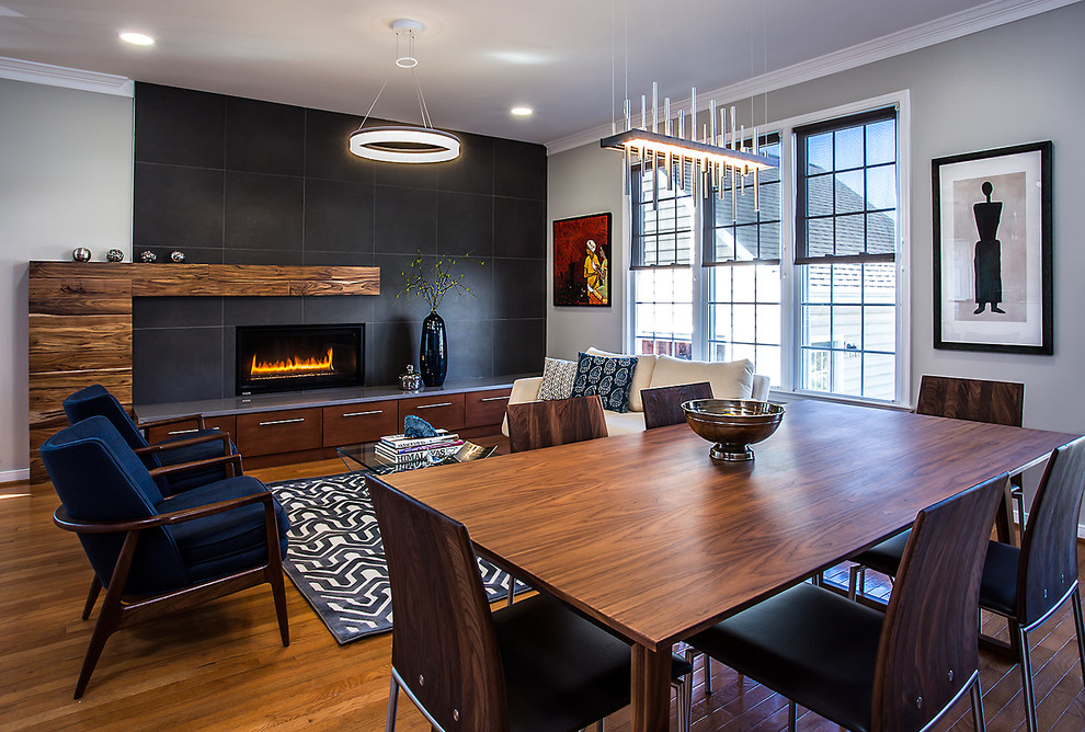 This is an example of a mid-sized contemporary dining room in Richmond with grey walls, medium hardwood floors, a tile fireplace surround and a ribbon fireplace.