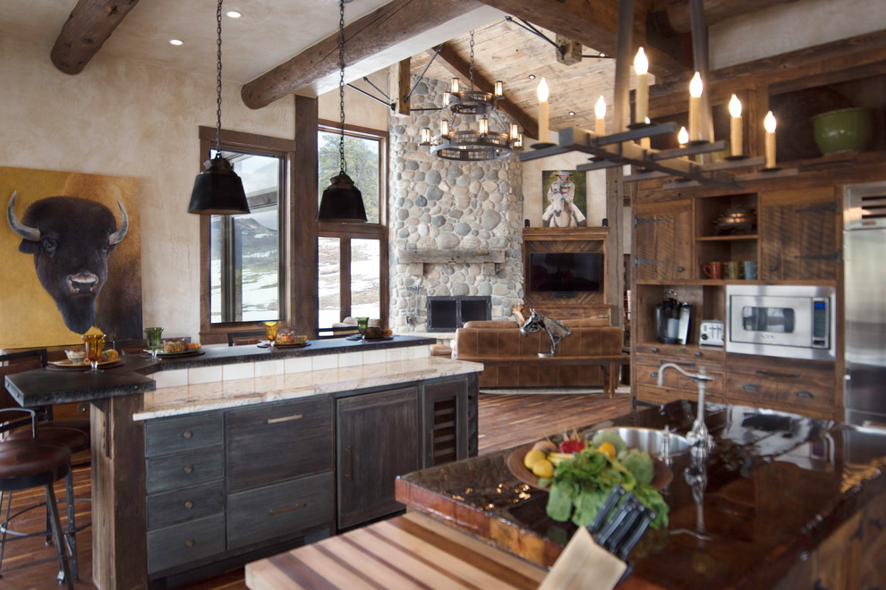 Design ideas for an expansive country eat-in kitchen in Albuquerque with a drop-in sink, flat-panel cabinets, distressed cabinets, granite benchtops, beige splashback, ceramic splashback, stainless steel appliances, medium hardwood floors and multiple islands.
