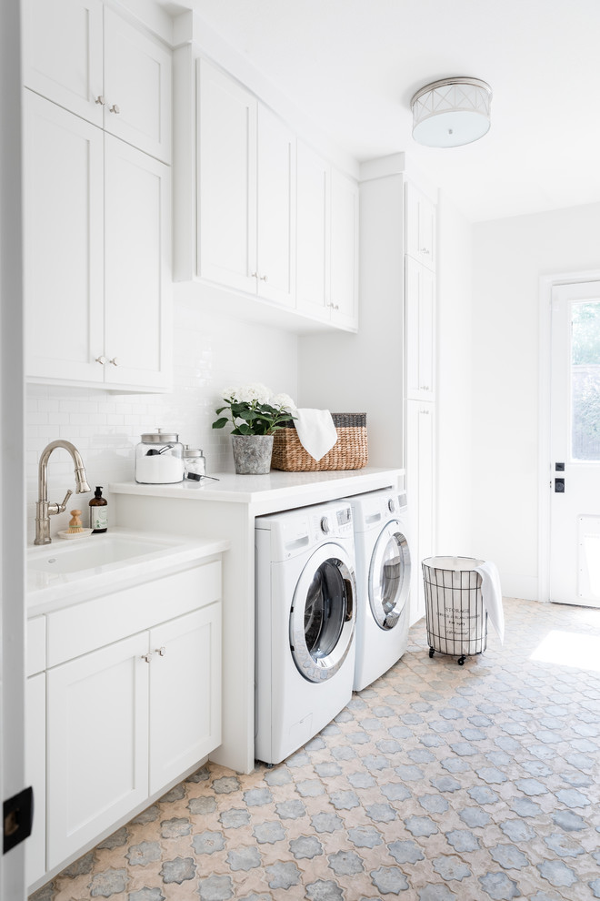 Photo of a transitional laundry room in Sacramento with an undermount sink, shaker cabinets, white cabinets, white walls, a side-by-side washer and dryer, multi-coloured floor and white benchtop.