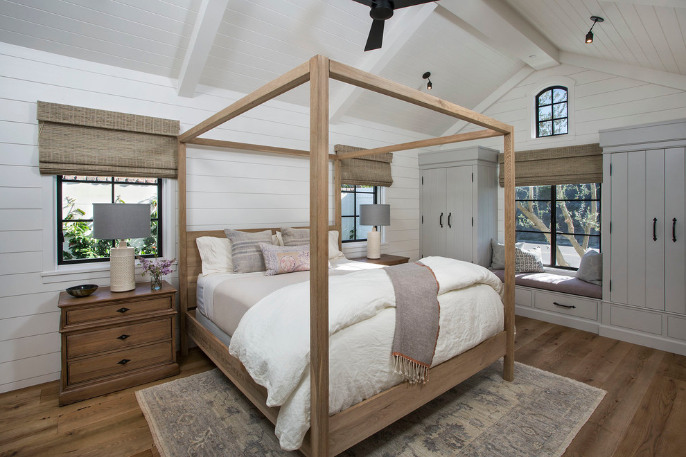 This is an example of a mid-sized transitional master bedroom in Orange County with white walls, medium hardwood floors and no fireplace.