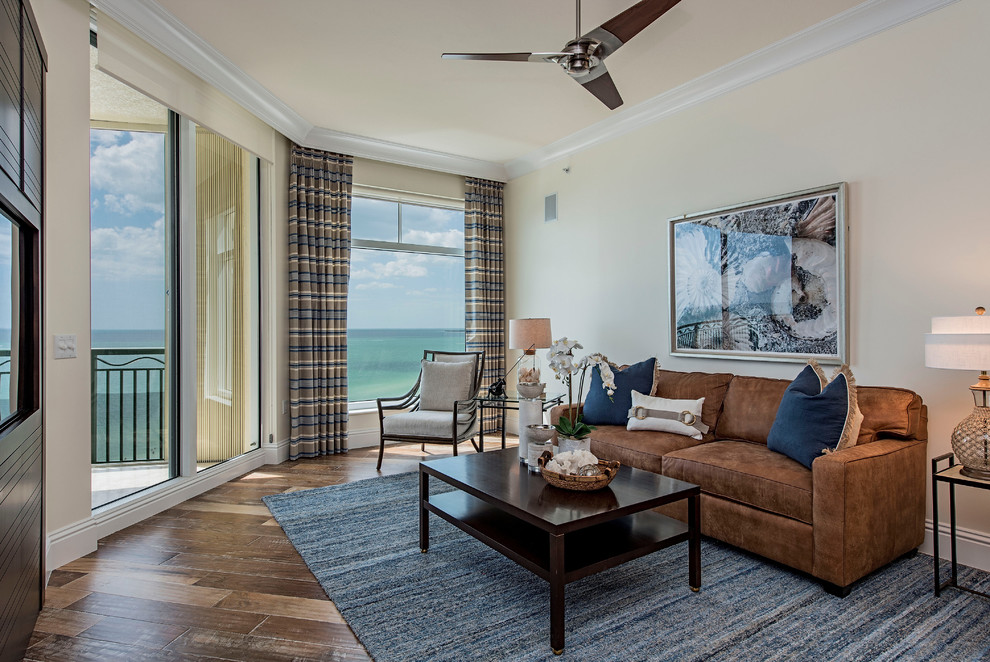 This is an example of a large beach style enclosed family room in Miami with a game room, beige walls, light hardwood floors and a built-in media wall.