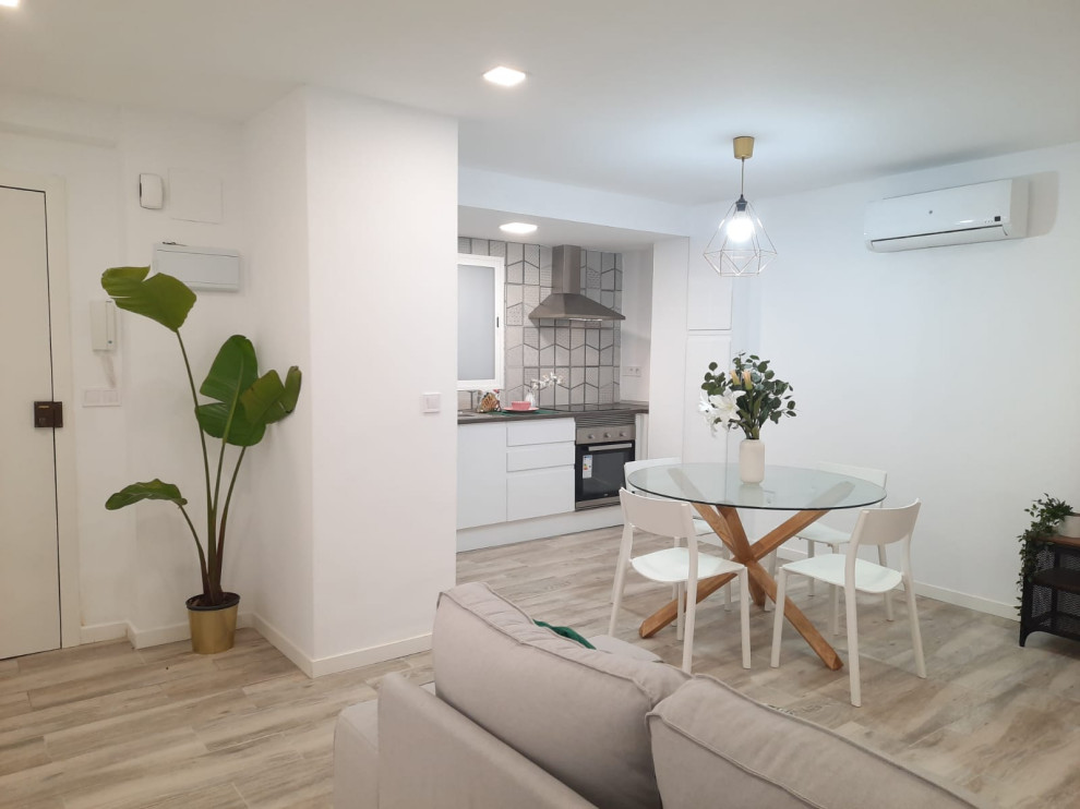 Diseño de comedor de cocina minimalista con paredes blancas y suelo laminado