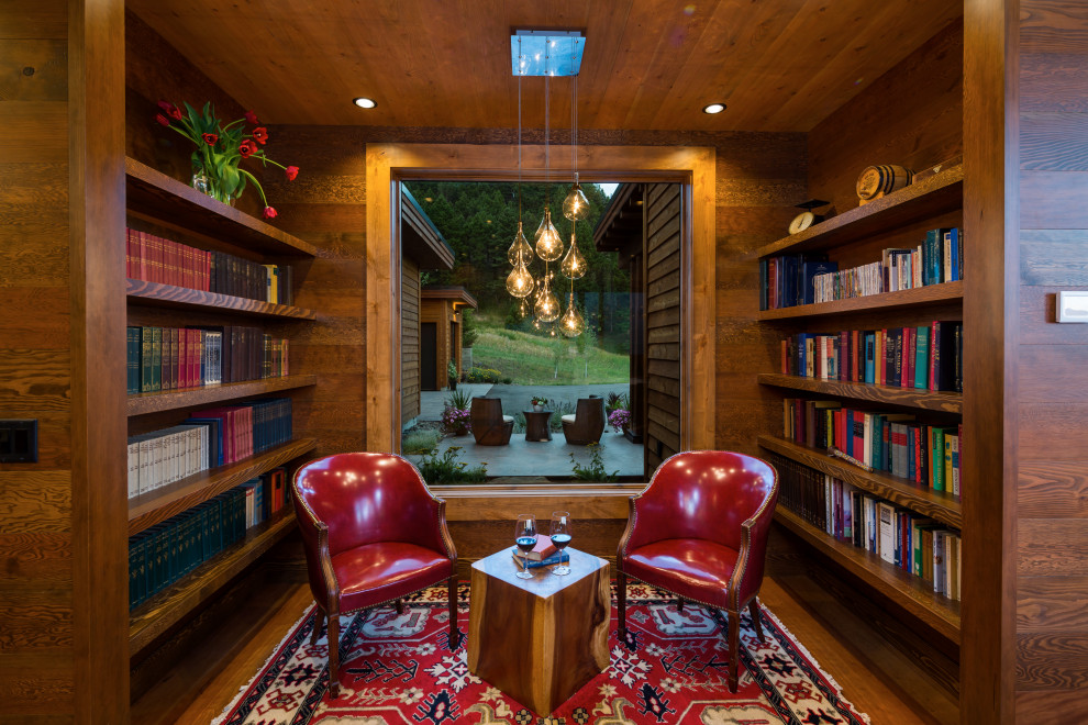 На фото: домашняя библиотека в стиле модернизм с паркетным полом среднего тона и деревянным потолком