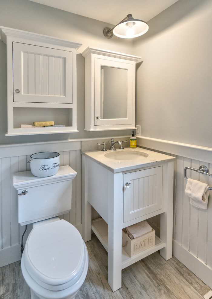 This is an example of a small modern l-shaped kitchen pantry in Boston with a farmhouse sink, shaker cabinets, blue cabinets, recycled glass benchtops, white splashback, ceramic splashback, stainless steel appliances, ceramic floors, with island and beige floor.