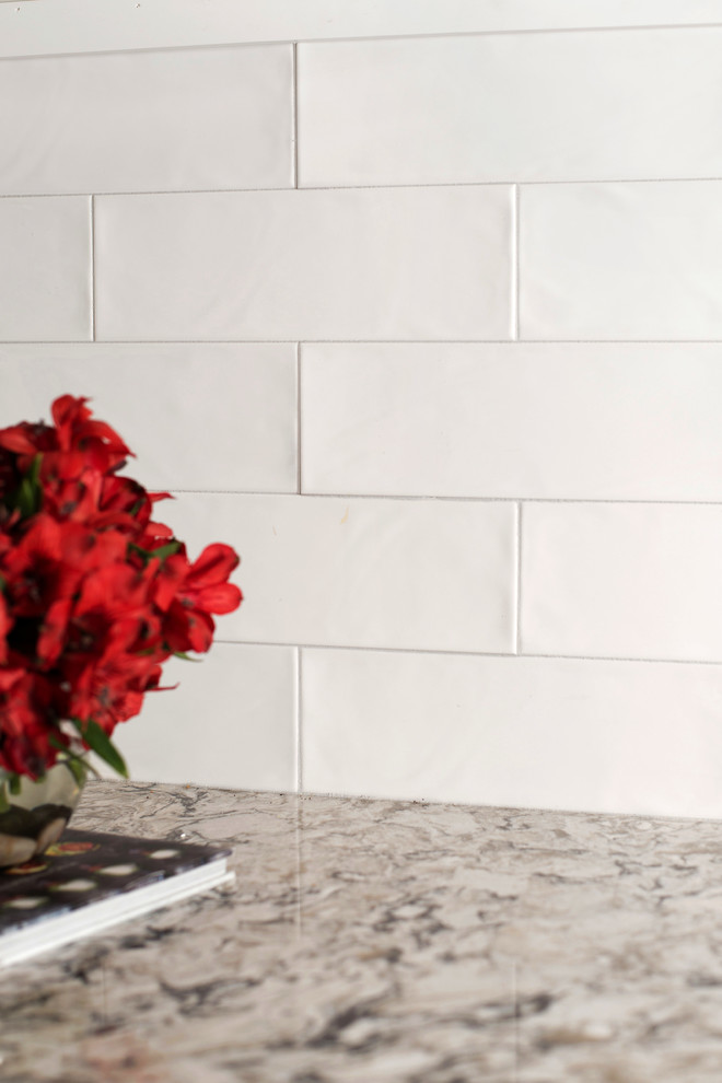Transitional l-shaped vinyl floor and brown floor eat-in kitchen photo with an undermount sink, beaded inset cabinets, white cabinets, quartz countertops, white backsplash, ceramic backsplash, stainless steel appliances and multicolored countertops