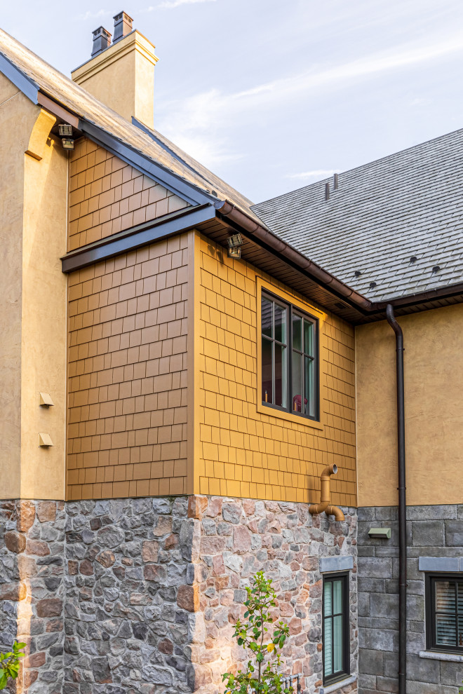 Exemple d'une très grande façade de maison beige en panneau de béton fibré et bardeaux à deux étages et plus avec un toit à deux pans, un toit en shingle et un toit gris.