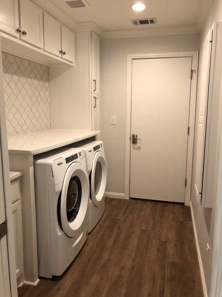 Design ideas for a mid-sized transitional single-wall dedicated laundry room in Dallas with an undermount sink, recessed-panel cabinets, white cabinets, granite benchtops, white walls, medium hardwood floors, a side-by-side washer and dryer, brown floor and white benchtop.