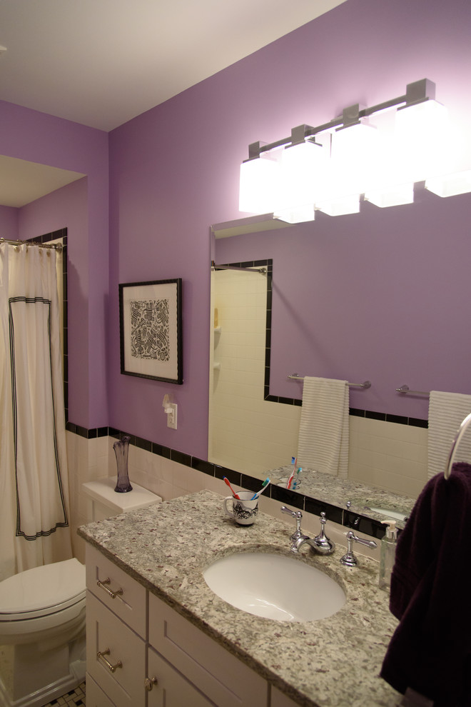 This is an example of a mid-sized contemporary 3/4 bathroom in Other with a two-piece toilet, black and white tile, purple walls, shaker cabinets, white cabinets, an alcove tub, a shower/bathtub combo, ceramic tile, ceramic floors, an undermount sink and granite benchtops.