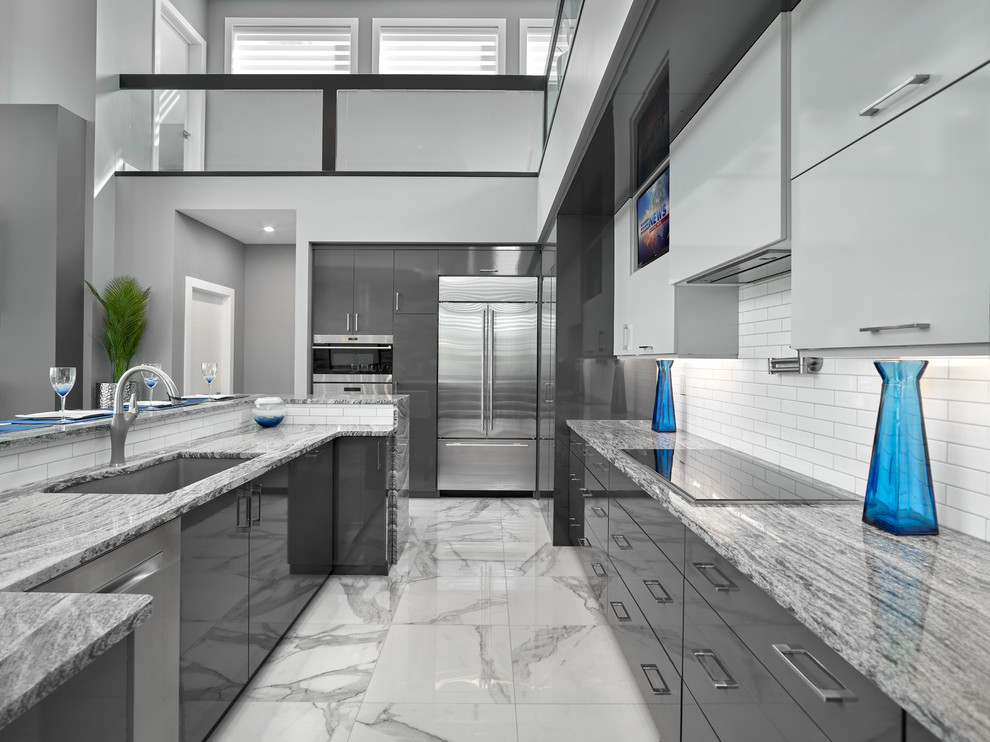 Design ideas for a mid-sized contemporary kitchen in Edmonton with an undermount sink, grey cabinets, quartz benchtops, white splashback, subway tile splashback, stainless steel appliances, porcelain floors, with island, grey floor, grey benchtop and flat-panel cabinets.