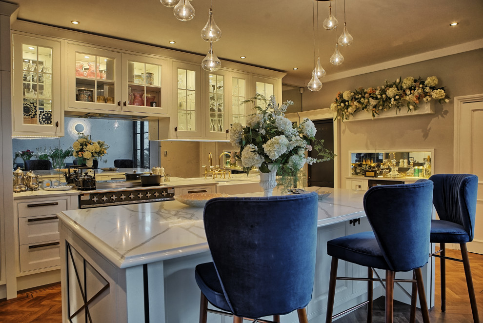 This is an example of a large traditional l-shaped eat-in kitchen in Other with a farmhouse sink, recessed-panel cabinets, medium wood cabinets, marble benchtops, glass sheet splashback, black appliances, vinyl floors and with island.