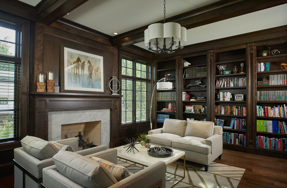 Large traditional home office in Grand Rapids with a library, brown walls, dark hardwood floors, a standard fireplace, a wood fireplace surround, brown floor, coffered and panelled walls.