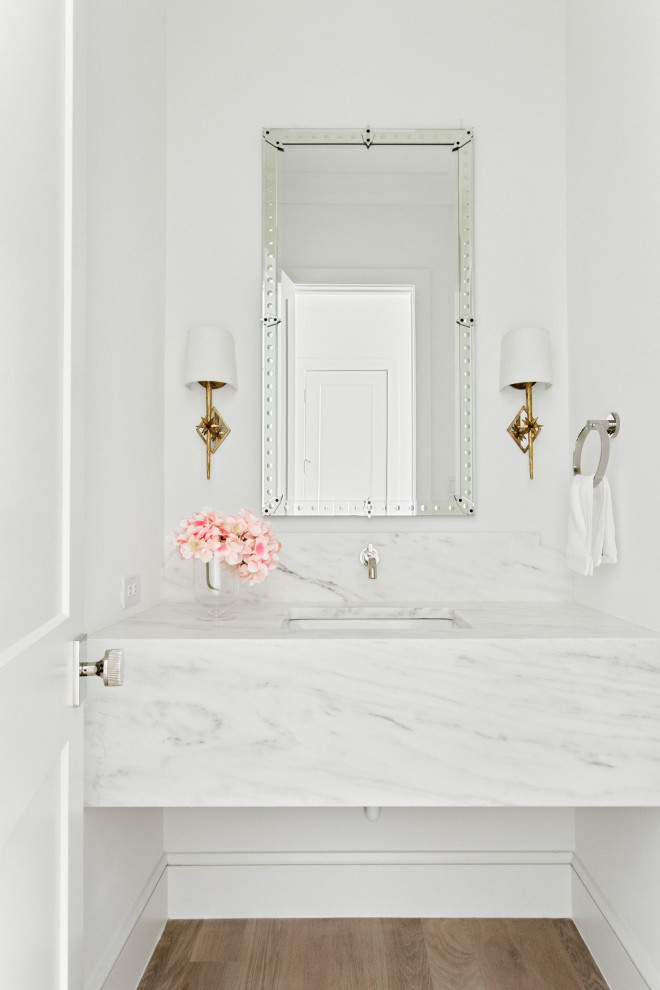 Cette image montre un WC et toilettes marin avec WC séparés, un mur blanc, parquet clair, un lavabo encastré, un plan de toilette en marbre, un sol beige, un plan de toilette blanc et meuble-lavabo suspendu.