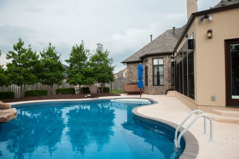 Example of a mid-sized transitional backyard stamped concrete and custom-shaped lap water slide design