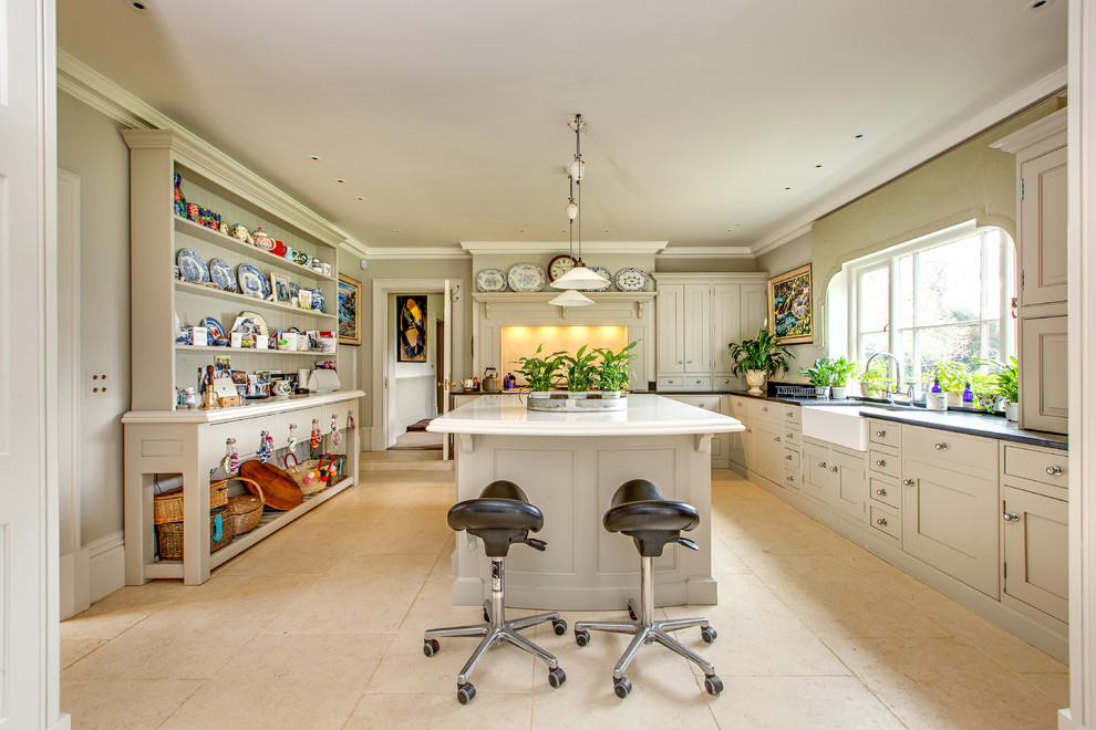 This is an example of a country l-shaped kitchen in Other with a farmhouse sink, shaker cabinets, beige cabinets, with island and beige floor.