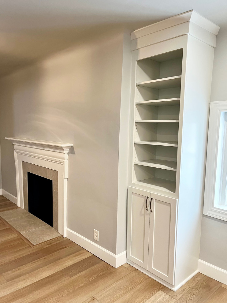 Mid-sized transitional vinyl floor and brown floor kitchen/dining room combo photo with white walls, a standard fireplace and a tile fireplace