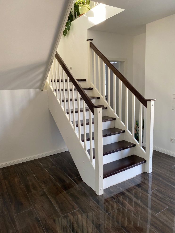 На фото: прямая бетонная лестница среднего размера в современном стиле с крашенными деревянными ступенями и деревянными перилами с