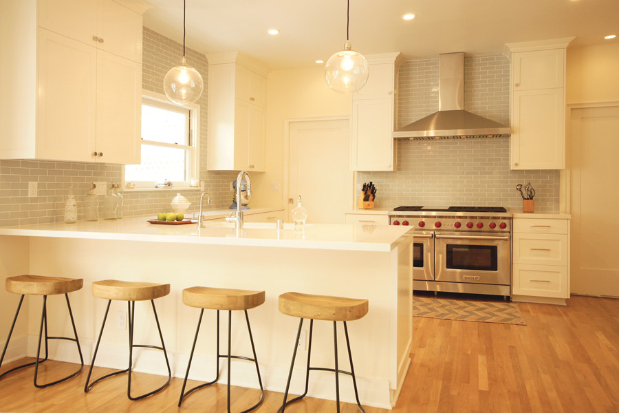 Kitchen - mid-sized transitional u-shaped light wood floor kitchen idea in Austin with a double-bowl sink, shaker cabinets, white cabinets, quartz countertops, blue backsplash, ceramic backsplash, stainless steel appliances, white walls and a peninsula