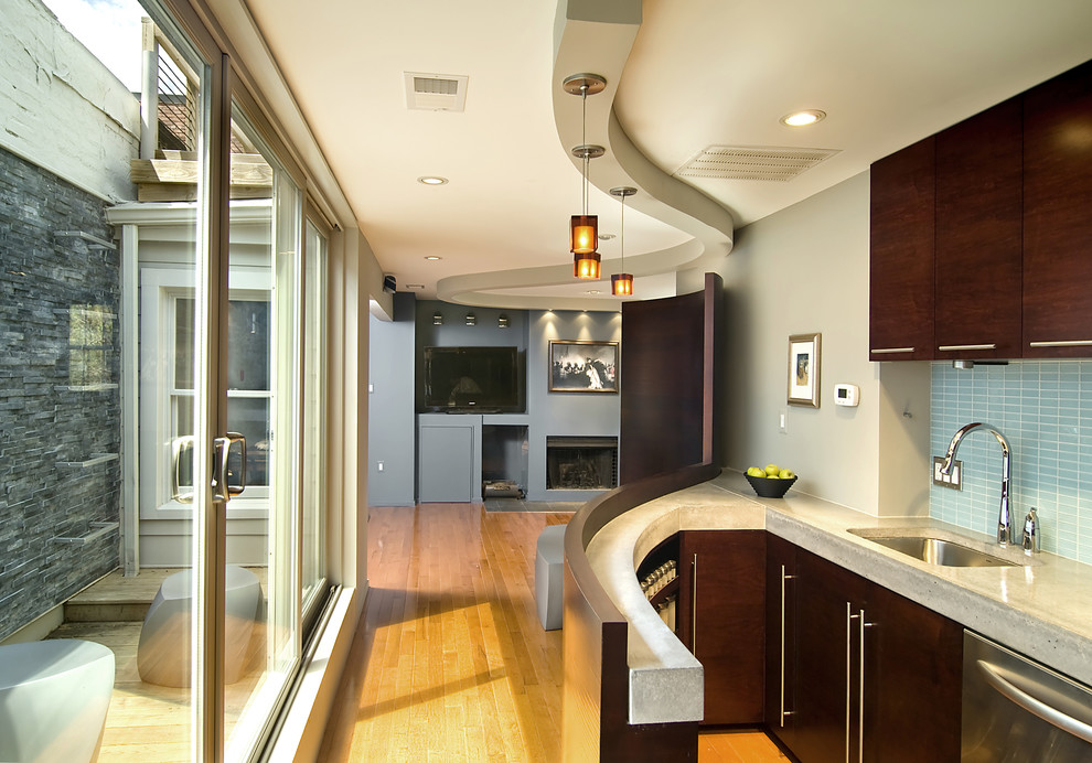 Contemporary kitchen in DC Metro with flat-panel cabinets, dark wood cabinets and blue splashback.