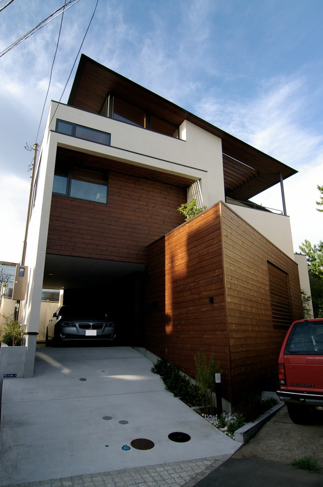 Photo of a midcentury split-level brown house exterior in Other with wood siding, a shed roof and a metal roof.