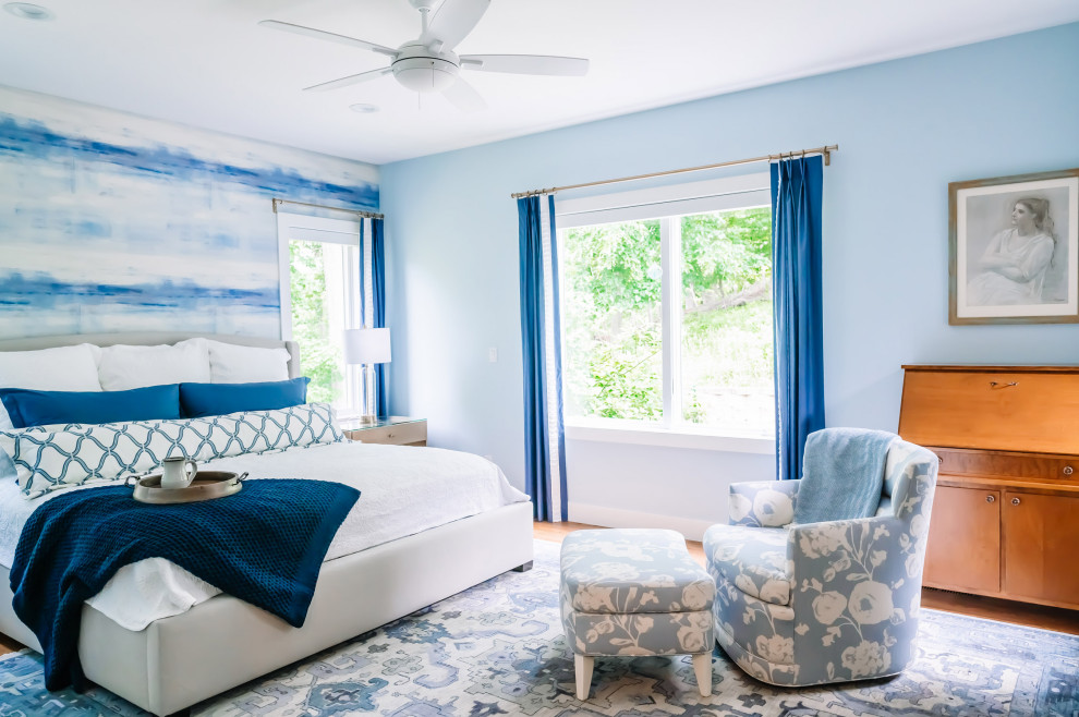 Exemple d'une chambre parentale moderne de taille moyenne avec un mur bleu, un sol en bois brun, aucune cheminée et un sol marron.